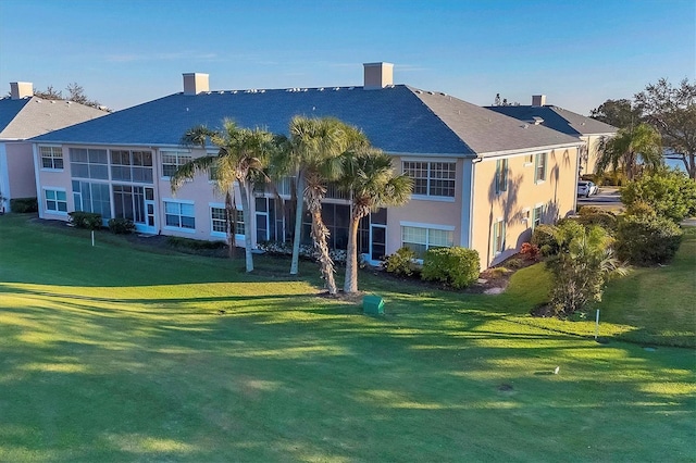 rear view of property featuring a yard