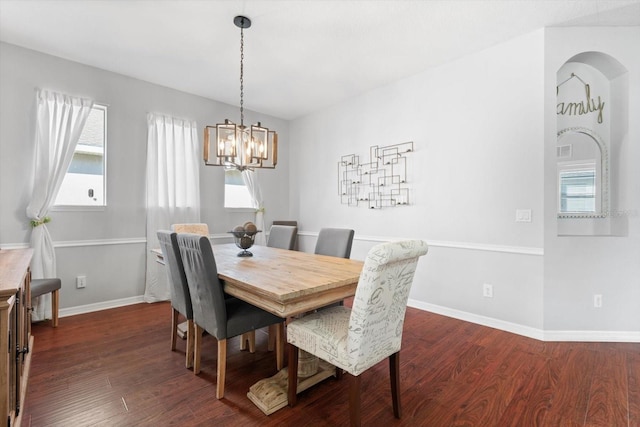 dining space with an inviting chandelier and dark wood-type flooring