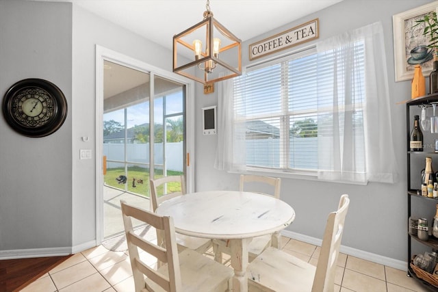 dining room featuring light tile patterned floors, a wealth of natural light, and a chandelier