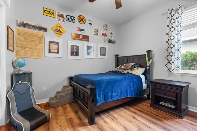 bedroom with multiple windows, wood-type flooring, and ceiling fan