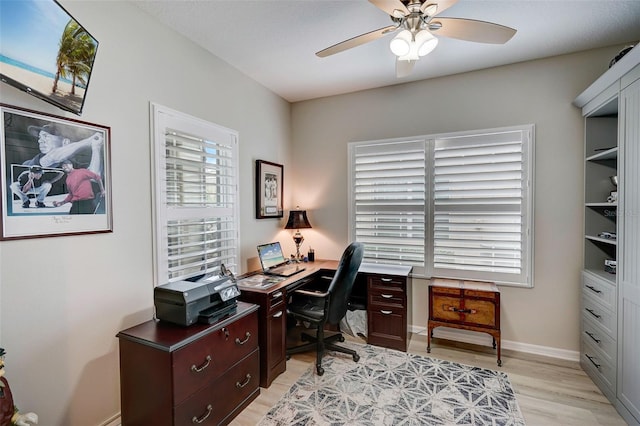 office area with light wood-type flooring and ceiling fan