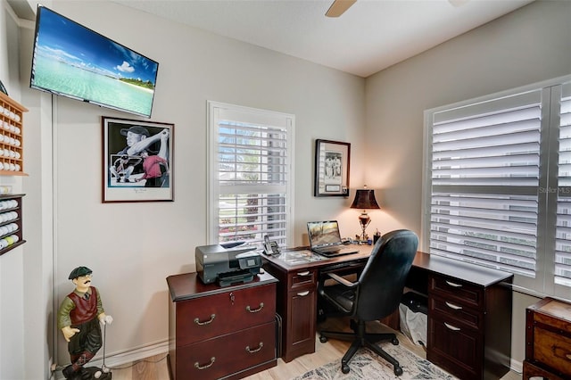 office with light wood-type flooring and ceiling fan