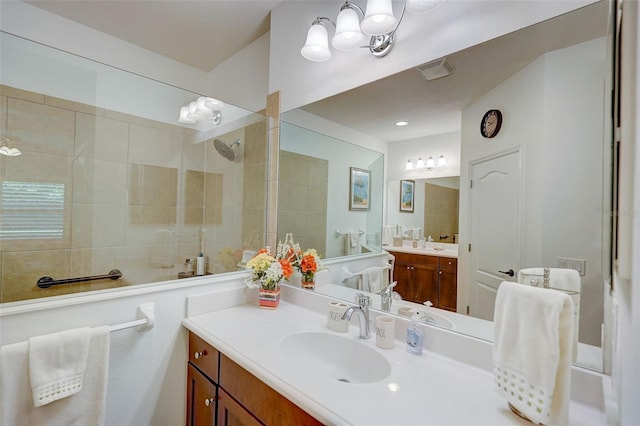 bathroom featuring a tile shower and vanity