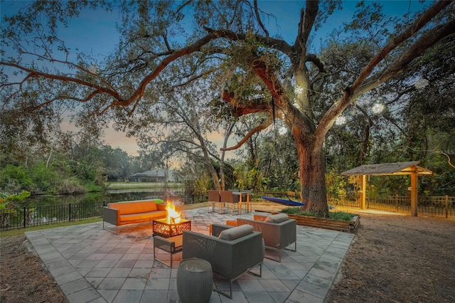 patio terrace at dusk featuring an outdoor living space with a fire pit