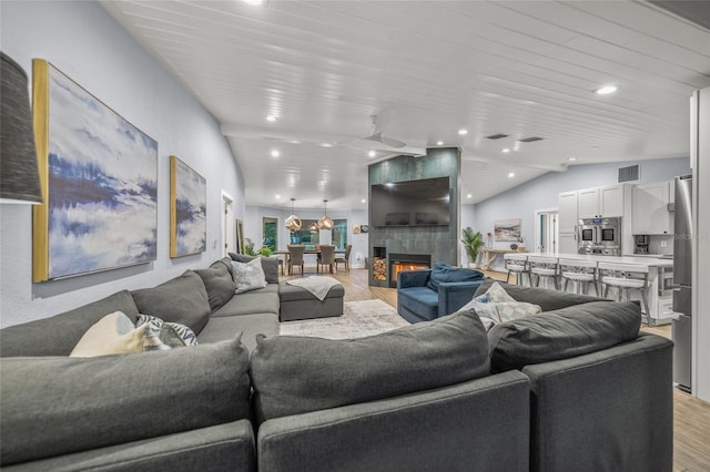 living room with lofted ceiling, a fireplace, wood ceiling, and light hardwood / wood-style flooring