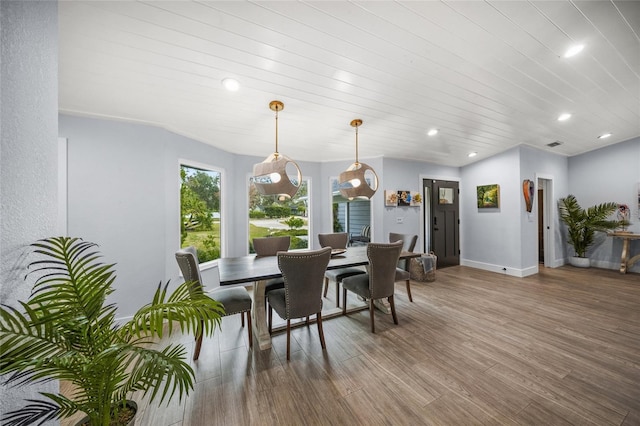 dining space featuring wood-type flooring and wooden ceiling