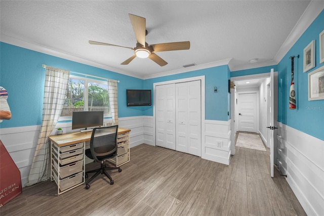 home office featuring ceiling fan, ornamental molding, light hardwood / wood-style floors, and a textured ceiling