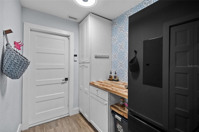 doorway with light hardwood / wood-style flooring and electric panel