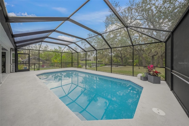 view of swimming pool featuring a patio area and glass enclosure