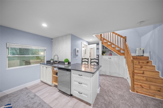 kitchen featuring dishwasher, white cabinetry, sink, and light colored carpet