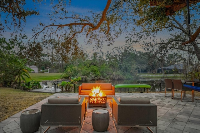 patio terrace at dusk featuring an outdoor fire pit