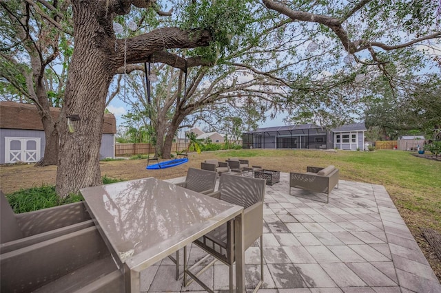 view of patio / terrace with a lanai and a storage unit