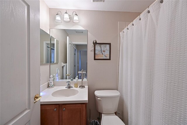 bathroom with vanity, toilet, and curtained shower