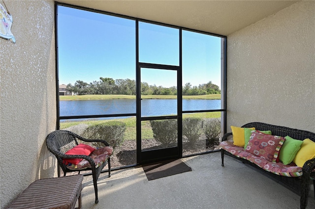 sunroom featuring a water view