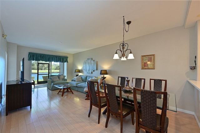 dining area with a notable chandelier and light wood-type flooring