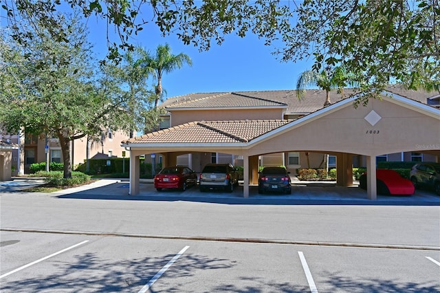 view of property featuring covered and uncovered parking