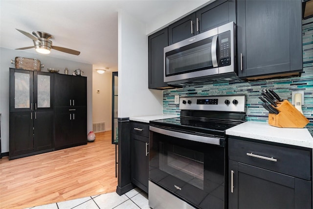 kitchen featuring tasteful backsplash, ceiling fan, appliances with stainless steel finishes, and light tile patterned flooring