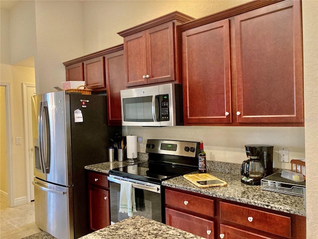 kitchen with light stone countertops, light tile patterned floors, and appliances with stainless steel finishes