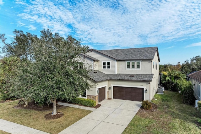 view of front of house with a garage, central air condition unit, and a front yard