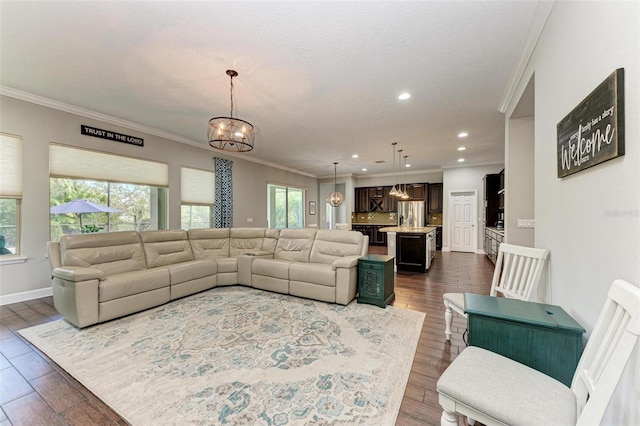 living area featuring dark wood finished floors, a notable chandelier, and ornamental molding