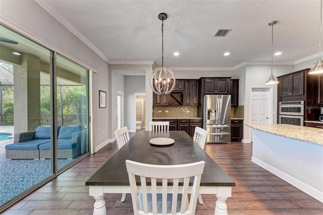 dining area with visible vents, an inviting chandelier, dark wood finished floors, and crown molding