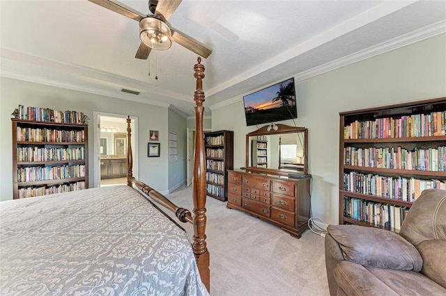 carpeted bedroom with visible vents, crown molding, ceiling fan, baseboards, and ensuite bathroom