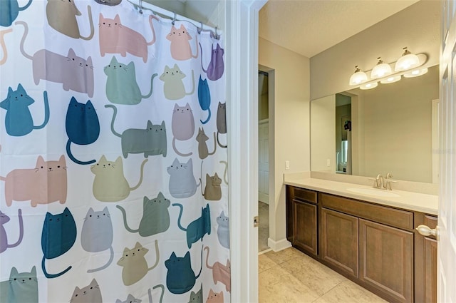 bathroom featuring curtained shower, vanity, and tile patterned flooring