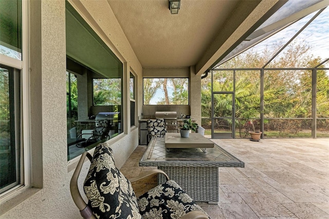 view of patio with glass enclosure and area for grilling