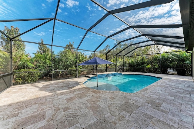 view of swimming pool with glass enclosure and a patio