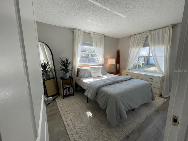 bedroom with wood-type flooring and a textured ceiling