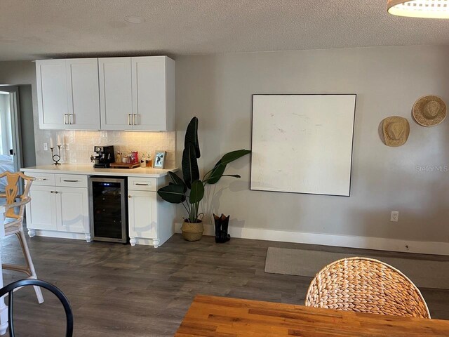 kitchen featuring tasteful backsplash, a textured ceiling, beverage cooler, dark wood-type flooring, and white cabinets