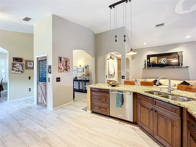 kitchen with visible vents, arched walkways, dishwasher, light stone counters, and a sink