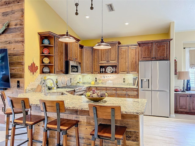 kitchen with a sink, stainless steel appliances, a peninsula, and open shelves