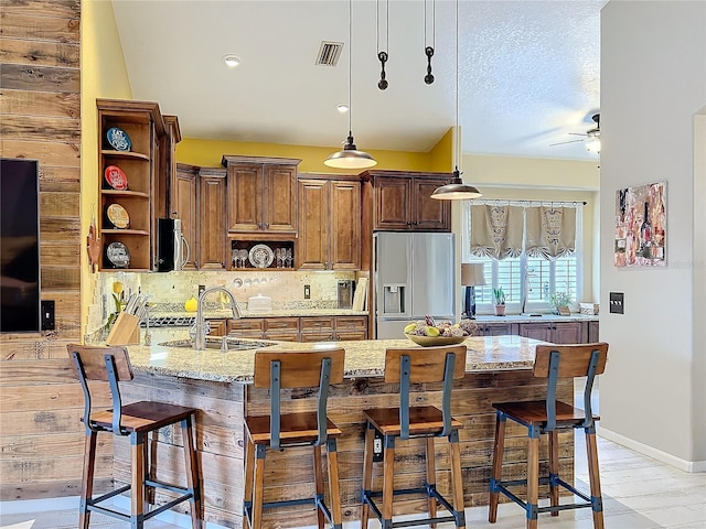 kitchen featuring open shelves, stainless steel appliances, tasteful backsplash, visible vents, and light stone countertops