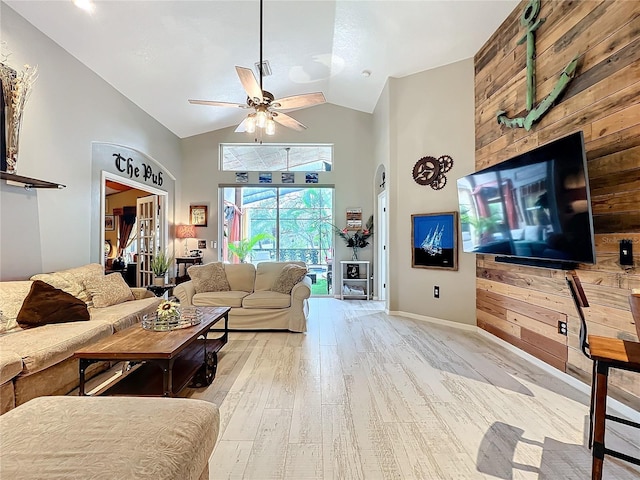 living room with ceiling fan, high vaulted ceiling, light wood finished floors, and baseboards