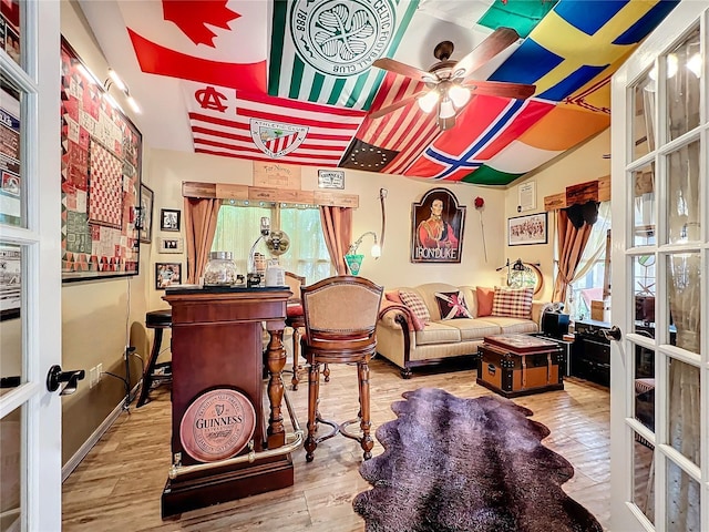 interior space featuring a ceiling fan, vaulted ceiling, wood finished floors, and french doors