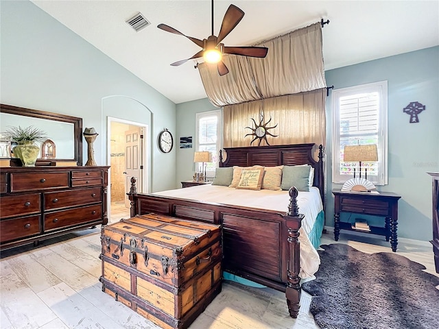 bedroom with lofted ceiling, ceiling fan, visible vents, and ensuite bathroom