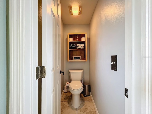 bathroom with toilet and baseboards