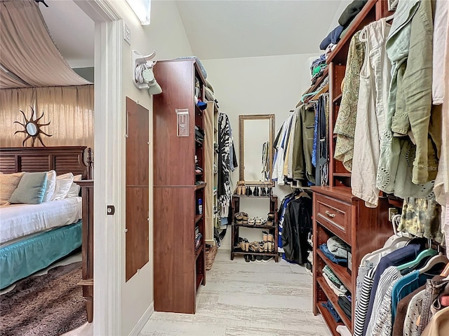 walk in closet with wood finished floors