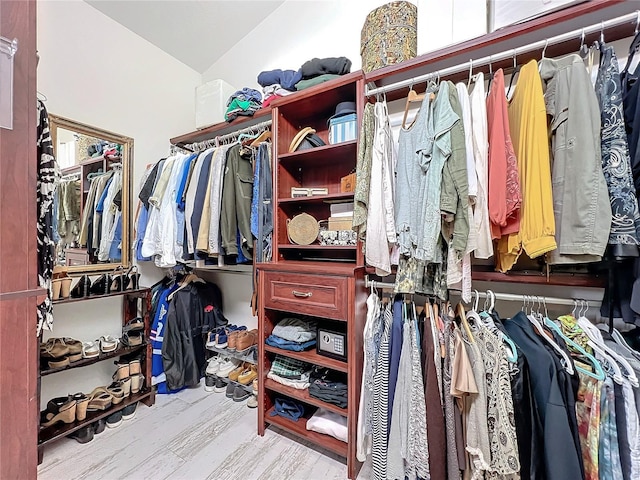 spacious closet with lofted ceiling and wood finished floors