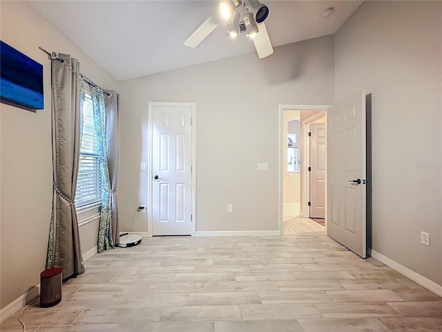 bedroom featuring light wood-style floors, vaulted ceiling, baseboards, and ceiling fan