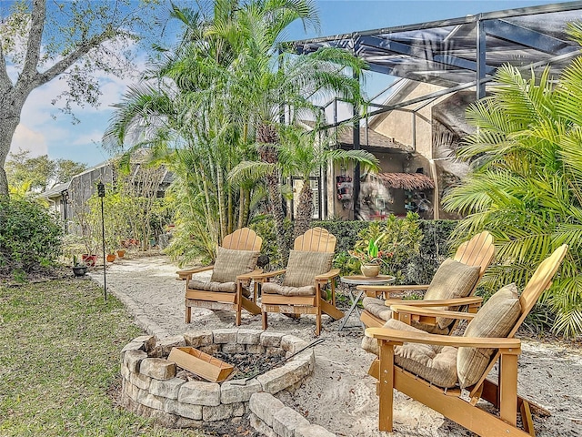 view of patio / terrace featuring glass enclosure and a fire pit