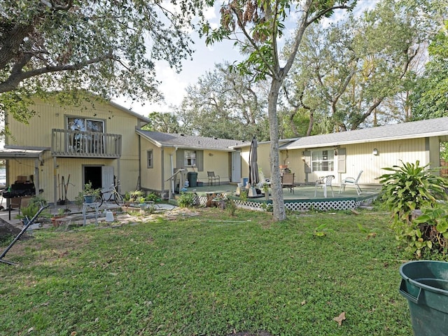 view of yard with a balcony and a patio