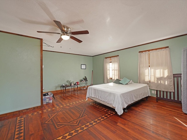 bedroom with crown molding, ceiling fan, wood-type flooring, and a textured ceiling