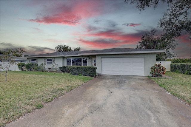 ranch-style house featuring a yard and a garage