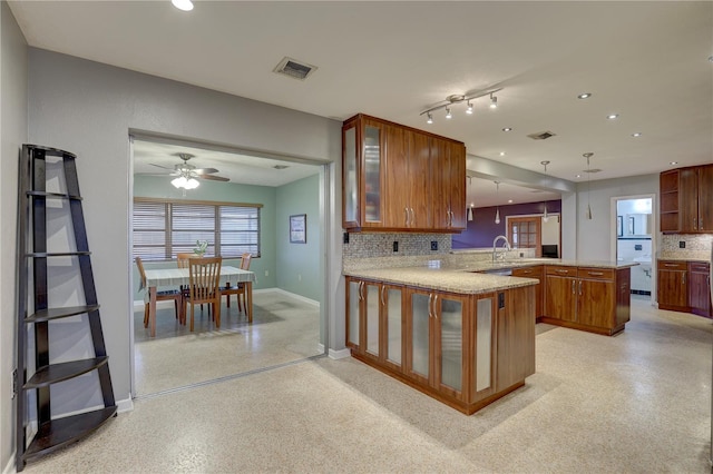 kitchen featuring tasteful backsplash, kitchen peninsula, ceiling fan, and decorative light fixtures