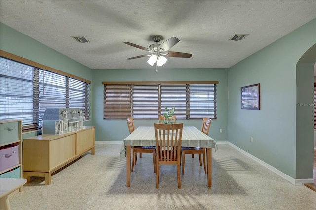 dining room featuring ceiling fan and a textured ceiling