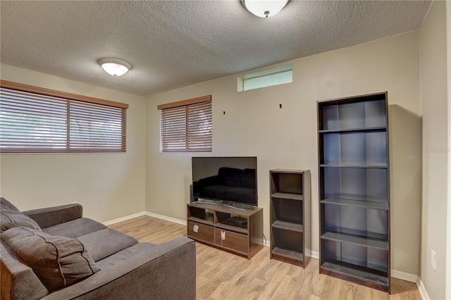 living room with a textured ceiling and light wood-type flooring