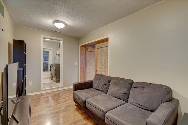 living room featuring light hardwood / wood-style flooring and a textured ceiling