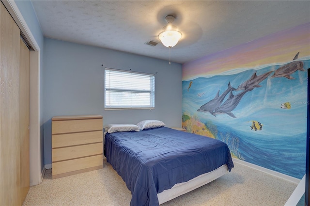 bedroom with ceiling fan, a textured ceiling, and a closet